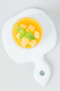 Chia tohum puding mango ile güzel gözlük yeşil nane yaprakları ile püre ve açık gri renkli - ham vejetaryen şekerli organik tatlı taze olgun tropikal meyve kesme.