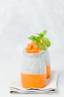 Chia tohum puding güzel gözlük yeşil nane ile kabak püresi ile yaprakları ve açık gri renkli - ham vejetaryen şekerli organik tatlı taze olgun turuncu sebze kesme.