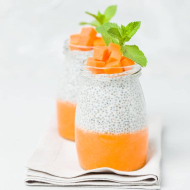 Chia tohum puding güzel gözlük yeşil nane ile kabak püresi ile yaprakları ve açık gri renkli - ham vejetaryen şekerli organik tatlı taze olgun turuncu sebze kesme.