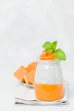 Chia tohum puding güzel gözlük yeşil nane ile kabak püresi ile yaprakları ve açık gri renkli - ham vejetaryen şekerli organik tatlı taze olgun turuncu sebze kesme.