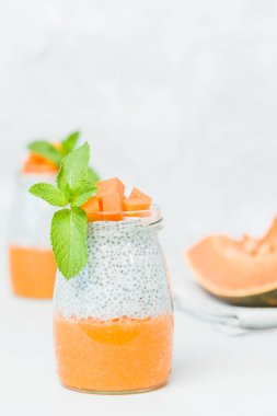 Chia tohum puding güzel gözlük yeşil nane ile kabak püresi ile yaprakları ve açık gri renkli - ham vejetaryen şekerli organik tatlı taze olgun turuncu sebze kesme.