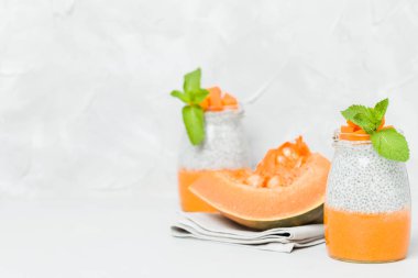 Chia tohum puding güzel gözlük yeşil nane ile kabak püresi ile yaprakları ve açık gri renkli - ham vejetaryen şekerli organik tatlı taze olgun turuncu sebze kesme.