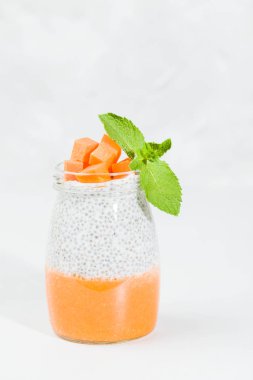 Chia tohum puding güzel gözlük yeşil nane ile kabak püresi ile yaprakları ve açık gri renkli - ham vejetaryen şekerli organik tatlı taze olgun turuncu sebze kesme.