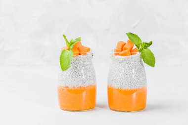 Chia tohum puding güzel gözlük yeşil nane ile kabak püresi ile yaprakları ve açık gri renkli - ham vejetaryen şekerli organik tatlı taze olgun turuncu sebze kesme.