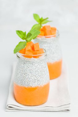 Chia tohum puding güzel gözlük yeşil nane ile kabak püresi ile yaprakları ve açık gri renkli - ham vejetaryen şekerli organik tatlı taze olgun turuncu sebze kesme.