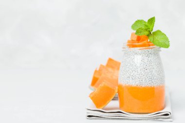 Chia tohum puding güzel gözlük yeşil nane ile kabak püresi ile yaprakları ve açık gri renkli - ham vejetaryen şekerli organik tatlı taze olgun turuncu sebze kesme.