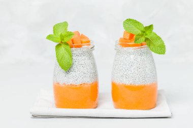 Chia tohum puding güzel gözlük yeşil nane ile kabak püresi ile yaprakları ve açık gri renkli - ham vejetaryen şekerli organik tatlı taze olgun turuncu sebze kesme.