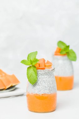 Chia tohum puding güzel gözlük yeşil nane ile kabak püresi ile yaprakları ve açık gri renkli - ham vejetaryen şekerli organik tatlı taze olgun turuncu sebze kesme.