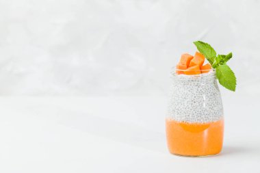 Chia tohum puding güzel gözlük yeşil nane ile kabak püresi ile yaprakları ve açık gri renkli - ham vejetaryen şekerli organik tatlı taze olgun turuncu sebze kesme.