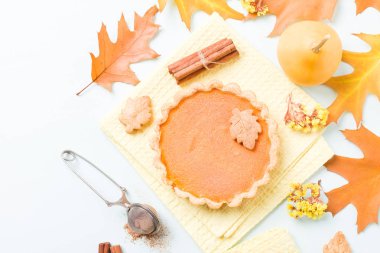 Tarçın ve çerezleri sarı sonbahar yaprakları - pastel mavi zemin üzerine sarı peçete ile kabak pasta üstten görünüm kapatmak kadar mevsimlik Amerikan geleneksel tatlı pişmiş gıda fotoğrafçılığı.