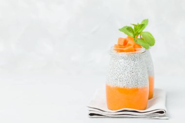 Chia tohum puding güzel gözlük yeşil nane ile kabak püresi ile yaprakları ve açık gri renkli - ham vejetaryen şekerli organik tatlı taze olgun turuncu sebze kesme.