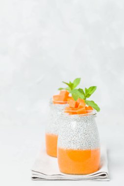 Chia tohum puding güzel gözlük yeşil nane ile kabak püresi ile yaprakları ve açık gri renkli - ham vejetaryen şekerli organik tatlı taze olgun turuncu sebze kesme.