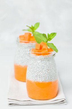 Chia tohum puding güzel gözlük yeşil nane ile kabak püresi ile yaprakları ve açık gri renkli - ham vejetaryen şekerli organik tatlı taze olgun turuncu sebze kesme.