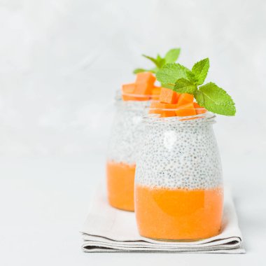 Chia tohum puding güzel gözlük yeşil nane ile kabak püresi ile yaprakları ve açık gri renkli - ham vejetaryen şekerli organik tatlı taze olgun turuncu sebze kesme.