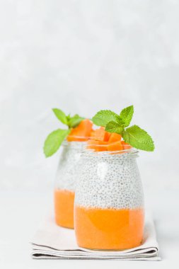 Chia tohum puding güzel gözlük yeşil nane ile kabak püresi ile yaprakları ve açık gri renkli - ham vejetaryen şekerli organik tatlı taze olgun turuncu sebze kesme.