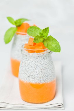 Chia tohum puding güzel gözlük yeşil nane ile kabak püresi ile yaprakları ve açık gri renkli - ham vejetaryen şekerli organik tatlı taze olgun turuncu sebze kesme.