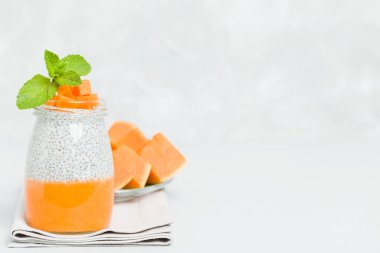 Chia tohum puding güzel gözlük yeşil nane ile kabak püresi ile yaprakları ve açık gri renkli - ham vejetaryen şekerli organik tatlı taze olgun turuncu sebze kesme.