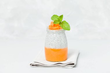 Chia tohum puding güzel gözlük yeşil nane ile kabak püresi ile yaprakları ve açık gri renkli - ham vejetaryen şekerli organik tatlı taze olgun turuncu sebze kesme.