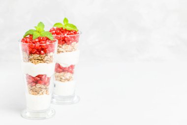 Nar parfe - granola pul, yoğurt ve olgun meyve şekerli organik katmanlı tatlı güzel gözlük kopya alanı ile gri arka plan üzerinde tohum. Doğal vejetaryen sağlıklı gıda.