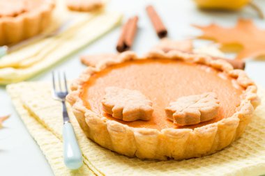 Tarçın ve çerezleri sarı sonbahar yaprakları - pastel mavi zemin üzerine sarı peçete ile kabak pasta üstten görünüm kapatmak kadar mevsimlik Amerikan geleneksel tatlı pişmiş gıda fotoğrafçılığı.