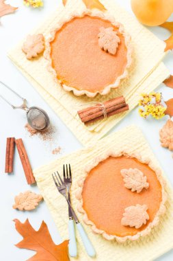 Tarçın ve çerezleri sarı sonbahar yaprakları - pastel mavi zemin üzerine sarı peçete ile kabak pasta üstten görünüm kapatmak kadar mevsimlik Amerikan geleneksel tatlı pişmiş gıda fotoğrafçılığı.