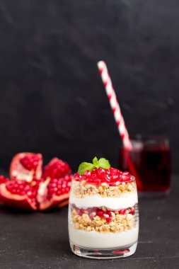 Nar parfe - granola pul, yoğurt ve olgun meyve şekerli organik katmanlı tatlı güzel gözlük kopya alanı siyah zemin üzerine tohum. Karanlık ruh tarzı doğal sağlıklı gıda.