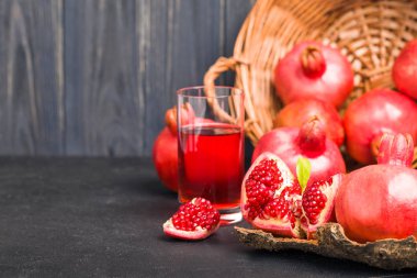Olgun kırmızı nar sepet ve tohumlar siyah arka plan - mevsimlik ham bütün ve açılan sulu meyve sağlıklı beslenme kavramı için karanlık ruh tarzında üzerine kaşık closeup Fotoğrafçılık.
