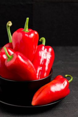 Plaka kopya alanı - portre fotoğraf Bütün taze olgun tatlı sebze organik sağlıklı gıda kavramı için modern karanlık ruh stilde siyah zemin üzerine kırmızı biber.