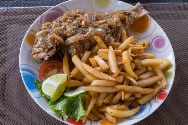 Tipik Senegal yemeği, soğan soslu balık ve kızarmış patates.