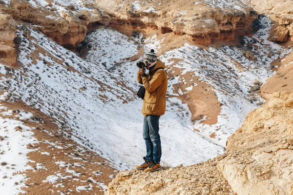 Bir kamera ile neşeli bir gezgin Kazakistan'daki Çarın Kanyonu'uçurumun kenarında duruyor. Analog Amerikan Grand Canyon