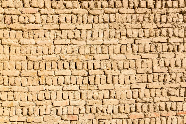 Ancient islamic Arabic muslim old town house wall built of yellow brown mud bricks on sunny day texture. Al Qasr, Dakhla Oasis, Western Desert, New Valley Governorate, Egypt, Africa.