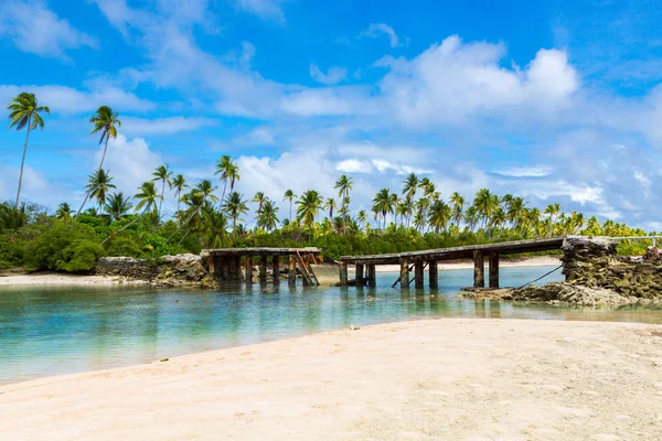 Broken bridge under palm trees between islets over lagoon, North Tarawa atoll, Kiribati, Micronesia, Gilbert islands, Oceania, South Pacific Ocean. Infrastructure problems of small island nations.