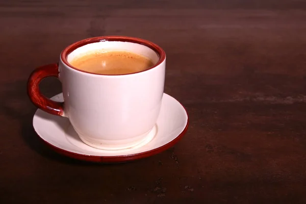 Una taza de café expreso sobre un fondo de madera oscura — Foto de Stock