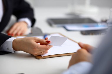 Ofiste elinde boş kartvizit tutan bir iş kadını.