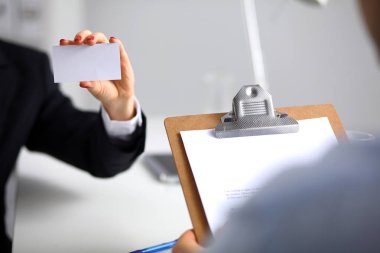 Ofiste elinde boş kartvizit tutan bir iş kadını.
