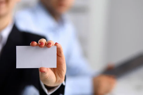 A business woman holding and showing empty business card in office