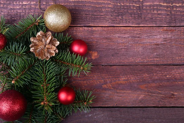Natale o Capodanno sfondo: albero di pelliccia, rami, palline di vetro colorato, decorazione e coni su uno sfondo di legno — Foto Stock
