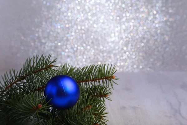 Dekorativer Hintergrund mit Tannenzweigen und blauen Kugeln auf dem Silber. Weihnachtskarten-Urlaubskonzept — Stockfoto