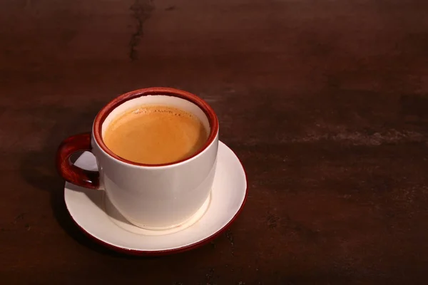 Una taza de café expreso sobre un fondo de madera oscura — Foto de Stock