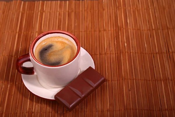Koffiekopje en chocolade op houten tafel textuur. Koffiepauze — Stockfoto