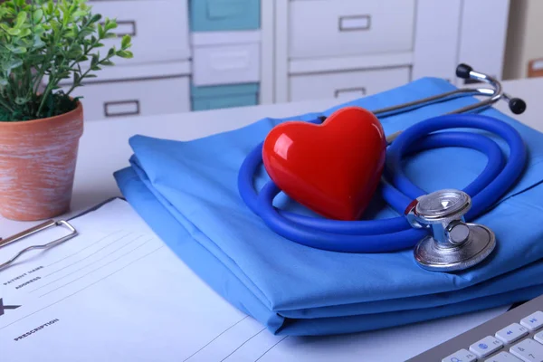 A medical stethoscope with red heart and RX prescription are lying on a medical uniform — Stock Photo, Image