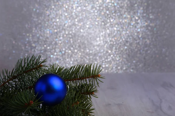 Decoratieve achtergrond met spar takken en blauwe ballen op het zilver. Kerstkaart Concept van de vakantie — Stockfoto