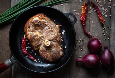 Tavada kuzu eti, tahta masada sebzeli.