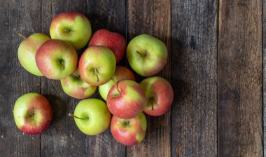 Elmalar ahşap masada, tahtalar eski.