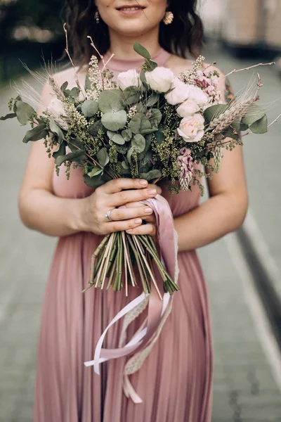 Pembe bir gelinlik ve alyans çiçek buketi ile mutlu ve gülümseyen kadın. Gelin, Nedime. Modern fotoğraf stili