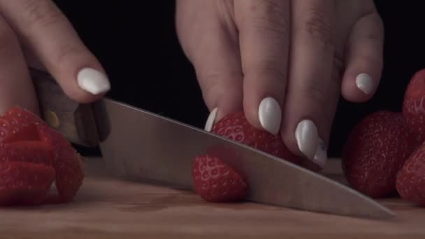 Girl cuts strawberries on the board — Stock Video