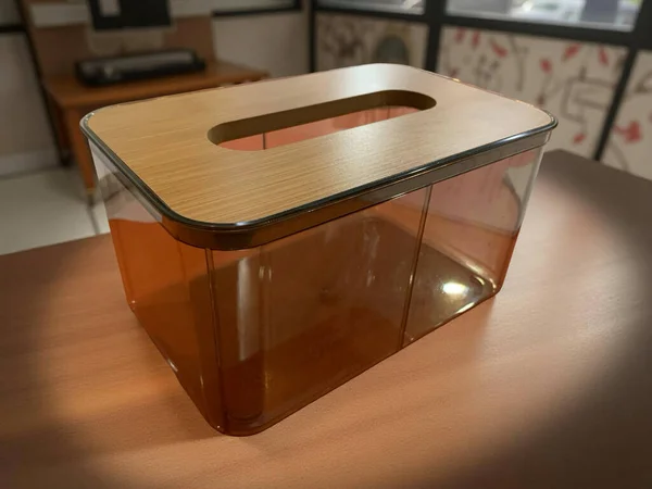 Bir bardak suyla ahşap bir masanın yakın çekimi.