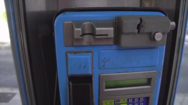 Telefon kulübesinden bir kart ve bozuk para makinesi yuvası