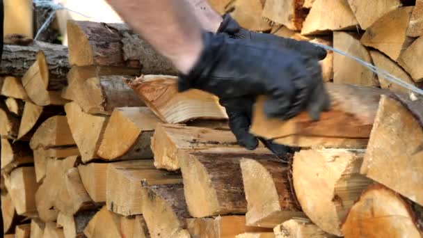 A hand grabbing two chopped firewoods on the storage — Stock Video