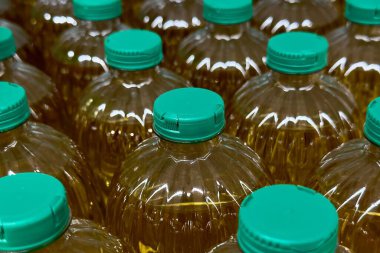 Bir bakkal koridorunda yeşil kapaklı birkaç şişe pişirme yağı sergileniyor..